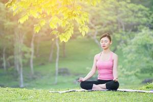 giovane bella donna asiatica che pratica yoga foto