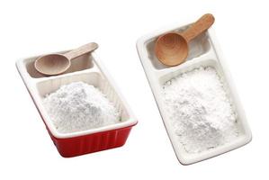 farina bianca in tazza di ceramica e cucchiaio su sfondo bianco foto