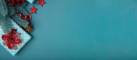 sfondo piatto di natale con regali, stella di Natale e pino su sfondo turchese foto