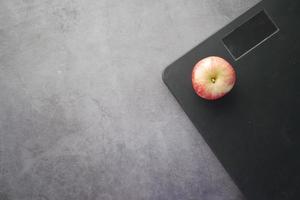 concetto di fitness con mela e bilancia su nero foto