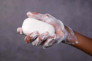 giovane che si lava le mani con acqua calda e sapone foto