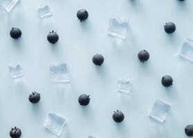 creativo estate modello fatto di mirtilli e ghiaccio cubi su leggero blu sfondo. frutta minimo concetto. di moda salutare cibo modello sfondo idea. piatto posizione. foto