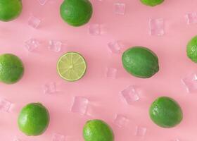 creativo estate modello fatto di verde lime e ghiaccio cubi su leggero pastello rosa sfondo. frutta minimo concetto. di moda salutare cibo modello sfondo idea. piatto posizione, superiore di Visualizza. foto