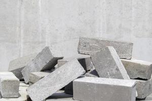 una pila di mattoni tipo cemento. il mattone pieno è usato per la costruzione. molti mattoni di cemento sfusi in cantiere. foto