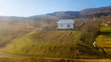 vista del paesaggio di un villaggio di montagna nei Carpazi in autunno dal finestrino del treno. una vista da un vecchio treno di un paesino di montagna foto