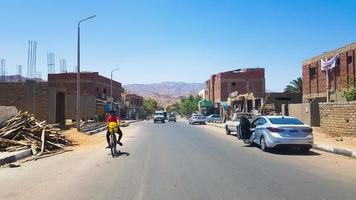 Egitto, dahab - 20 giugno 2019. un arabo in bicicletta lungo una delle strade di dahab. strada del deserto. edifici residenziali egiziani. la città di dahab. foto