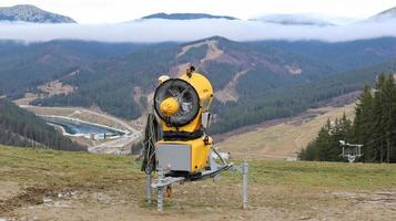 mitragliatrice, cannone sparaneve per la produzione di neve artificiale in montagna, preparazione per lo sci. fare la neve. la produzione di neve mediante pompaggio di acqua e aria compressa viene utilizzata nelle stazioni sciistiche. foto