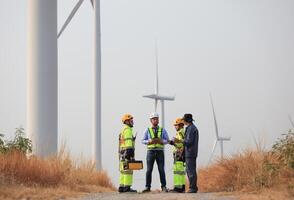 specialista vento turbina squadra di ingegneri discutere verde energia produzione nel vento turbine azienda agricola o mulini a vento campo. squadra di ingegnere energia pianificazione attività nel mulini a vento industriale la zona foto