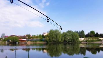 canna da pesca sullo sfondo di un bellissimo lago sullo sfondo. foto