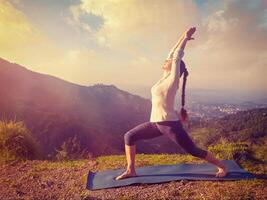 donna fare yoga asana virabhadrasana 1 - guerriero posa all'aperto foto