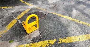 barriera di parcheggio in ferro arancione sulla strada. una barriera pieghevole impedisce il parcheggio in questa posizione. sicurezza dell'auto foto