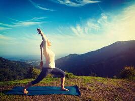 donna fare yoga asana virabhadrasana 1 - guerriero posa all'aperto foto