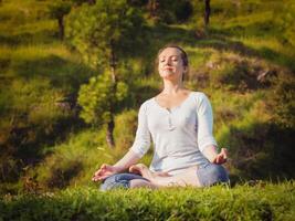 giovane sportivo in forma donna fare yoga loto posa oudoors foto