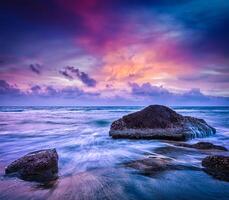 onde e rocce sulla spiaggia del tramonto foto