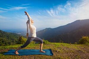 donna fare yoga asana virabhadrasana 1 guerriero posa all'aperto foto