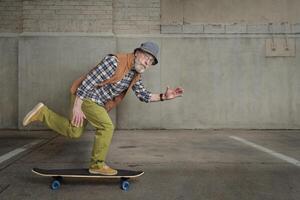 anziano uomo equitazione un' lungo crociera skateboard foto