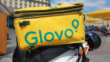 ucraina, kiev - 29 agosto 2020. ciclomotore parcheggiato con borsa gialla con logo glovo vicino al primo piano di mcdonald. servizio di corriere che consegna la merce ordinata tramite un'applicazione mobile. fotografia editoriale. foto