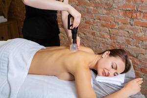giovane donna ottenere un' indietro massaggio nel un' terme salone. bellezza trattamento concetto. foto