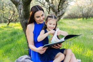 madre e figlia siamo lettura insieme nel il parco foto