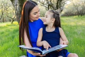 madre e figlia siamo lettura insieme nel il parco foto