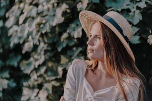 donna con cannuccia cappello sta nel davanti di vigneto. lei è indossare un' leggero vestito e in posa per un' foto. viaggio concetto per diverso paesi foto