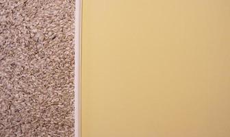 intonaco decorativo e parete semidipinta in beige. sfondo strutturato. parete bicolore. lo sfondo giallo e beige è dipinto in due colori diversi. carta da parati astratta. copia spazio foto