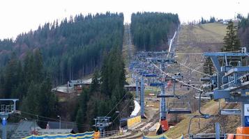 Ucraina, Bukovel - 20 novembre 2019. Vista autunnale della stazione sciistica con una seggiovia sullo sfondo dei pendii montani autunnali e l'infrastruttura in costruzione di una stazione sciistica invernale. foto