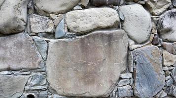 la trama del muro di pietra. fondo di struttura della parete di pietra del vecchio castello. muro di pietra come sfondo o texture. parte di un muro di pietra, per lo sfondo o la trama. modello colore grigio design in stile moderno foto