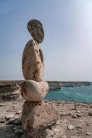 scultura simbolo fatto di grande ciottoli contro il blu cielo foto