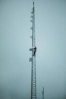 torre dell'antenna rampicante dell'operatore delle telecomunicazioni foto