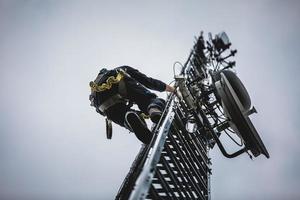 torre dell'antenna rampicante dell'operatore delle telecomunicazioni foto