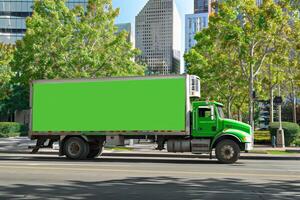 verde camion rotoli giù città strada, passaggio edifici e alberi. verde posto. foto