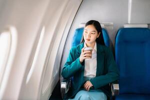 asiatico donna seduta nel un' posto a sedere nel aereo e guardare su il finestra andando su un' viaggio vacanza viaggio concetto.cattura il fascino di voglia di girovagare foto