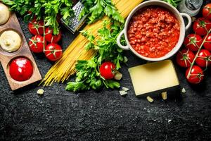 pasta sfondo. asciutto spaghetti con bolognese salsa, erbe aromatiche, pomodori e formaggio. foto