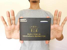 indonesiano libro veicolo proprietari o comunemente conosciuto come buku pemilik kendaran bermotore bpkb. Tenere bpkb foto