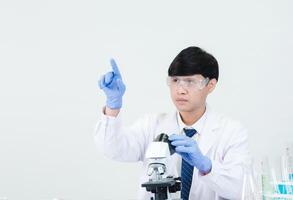 ritratto asiatico uomo alunno scienziato medico nel camicia toga uno persona lavoro lavoro pianta guardare mano Tenere controllo microscopio su bianca tavolo vedere il risultati di scientifico esperimenti dentro laboratorio foto