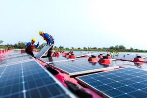 fotovoltaico ingegneri opera su galleggiante fotovoltaico. lavoratori ispezionare e riparazione il solare pannello attrezzatura galleggiante su acqua. ingegnere Lavorando impostare galleggiante solare pannelli piattaforma sistema su il lago. foto