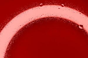 rosso liquido gocce schizzato su pulito superficie con rosso leggero a partire dal parte inferiore. circolatorio sistema illustrativo azione foto