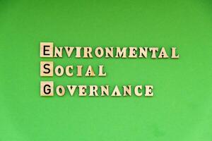 esg iscrizione ambientale sociale governo investimento attività commerciale concetto. testo su di legno bloccare su verde sfondo. società e aziendale governo foto