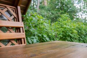 di legno tavolo a alcova nel giardino all'aperto. sfondo di verde. modello finto su podio per annuncio. connessione con natura foto