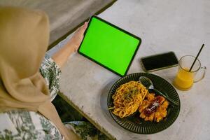 verde schermo ipad o tavoletta con bar ambiance e cibo su tavolo foto