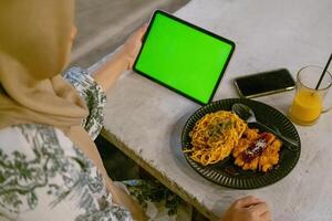 verde schermo ipad o tavoletta con bar ambiance e cibo su tavolo foto