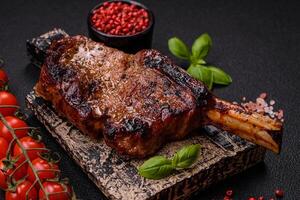 delizioso succoso Manzo bistecca su il osso, tomahawk con sale, spezie e erbe aromatiche foto