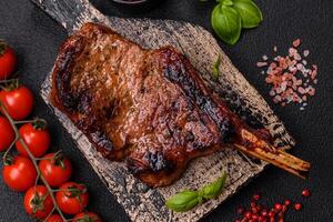 delizioso succoso Manzo bistecca su il osso, tomahawk con sale, spezie e erbe aromatiche foto