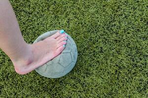 ragazza a piedi nudi e vecchio calcio palla foto