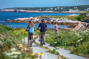 famiglia godendo senza fretta bicicletta cavalcata lungo panoramico costiero sentiero, soleggiato estate pomeriggio foto