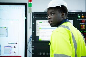 ritratto di afroamericano maschio ingegnere Lavorando su computer controllo nel fabbrica foto