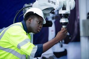 tecnico chi mantiene un' piccolo robot braccio il operazione di un' piccolo robot braccio Usato nel industria è essere riparato. foto