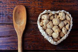 carne di soia, pezzi in un cesto a forma di cuore. pezzi di semi di soia crudi su fondo di legno rustico foto