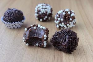 brigadeiro, brigadier, dolce al cioccolato tipico della cucina brasiliana ricoperto di particelle, su fondo in legno. foto